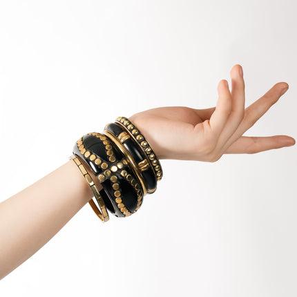 Close-Up of Polished Gold Studs on Glossy Black Bangles Detail