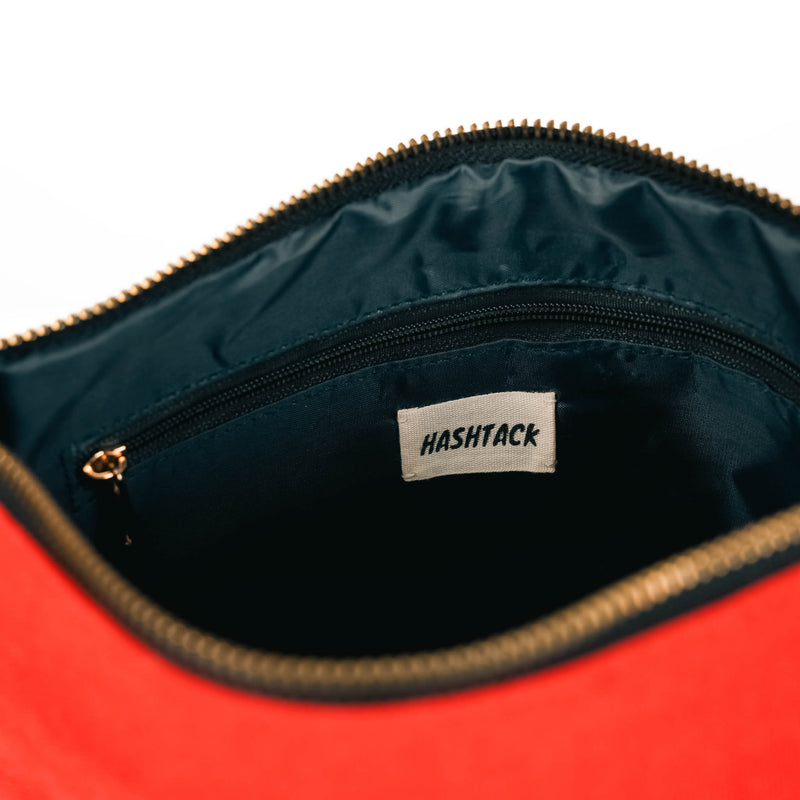 Crimson red fabric wristlet pouch open to show its interior and wrist strap