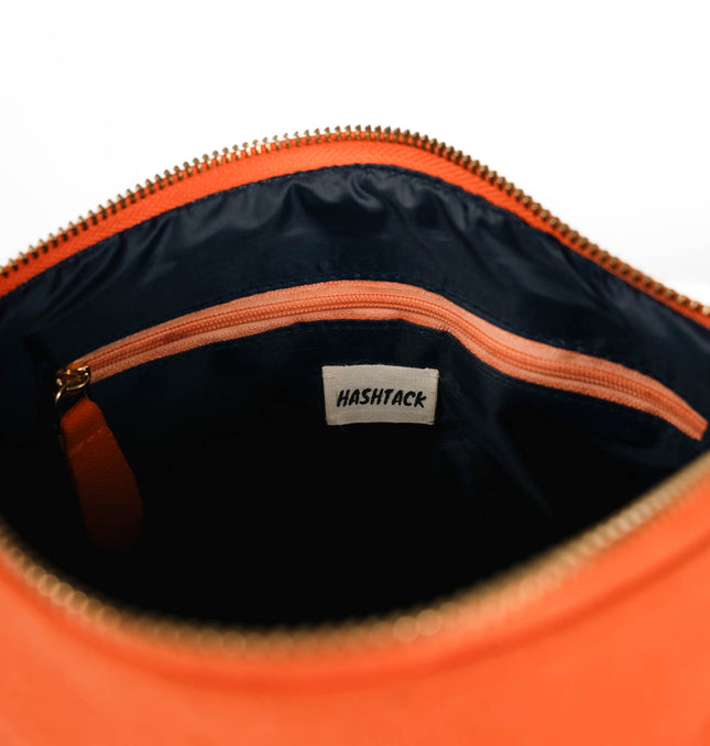 Bright orange utility pouch for women showing strap detail