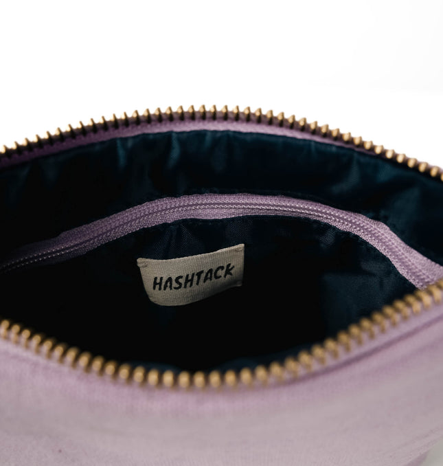 Side angle of violet lilac utility pouch highlighting secure gold-tone metal zipper and wristlet strap