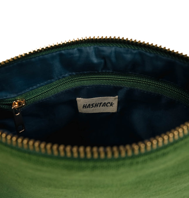 Side angle of moss green utility pouch highlighting secure gold-tone metal zipper and wristlet strap