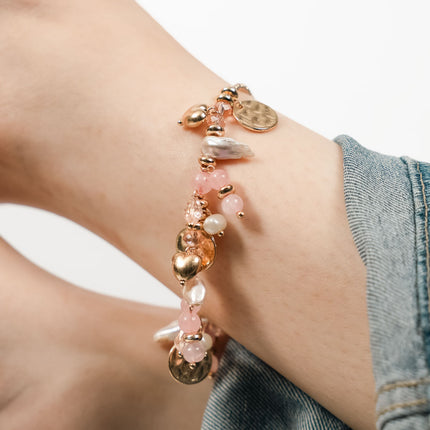 Bracelet with pink beads and gold accents on a wrist - Hashtack
