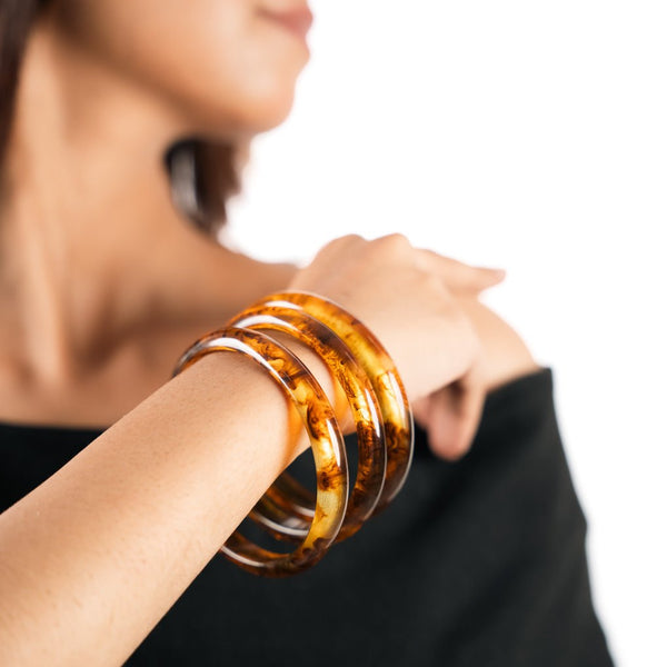 Slim amber resin bangles with a glossy shine